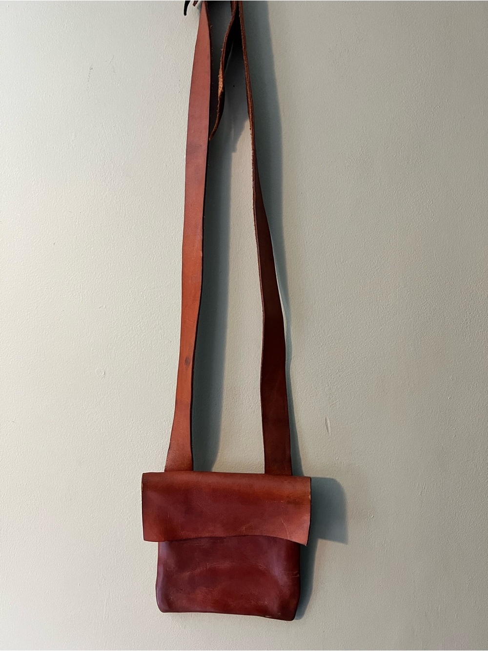 Rustic genuine leather home made flap top adjustable crossbody bag.